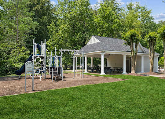 A playground with a swing set and a gazebo-like structure in the background at The Overlook at Quantico Apartments, Triangle, VA, 22172