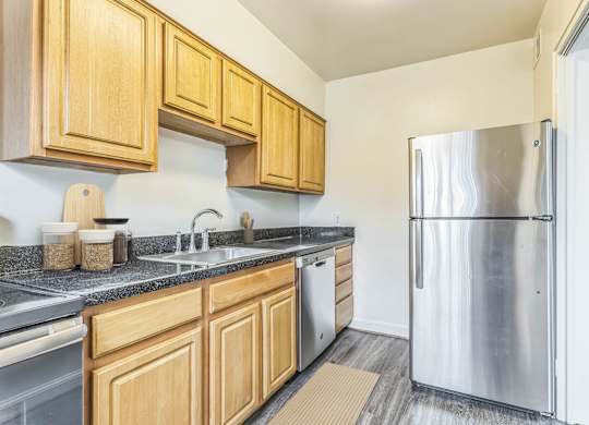 A kitchen with wooden cabinets and a stainless steel refrigerator at The Fields of Silver Spring, Silver Spring