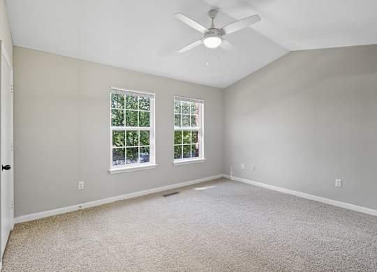Carpeted Bedroom With Ceiling Fan at Greens at Stonecreek, Lithonia, Georgia