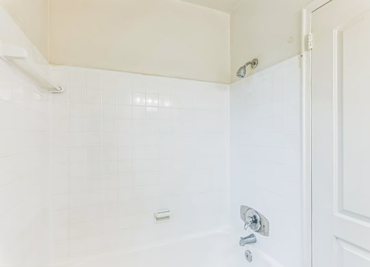 A white bathroom with a shower and a door.