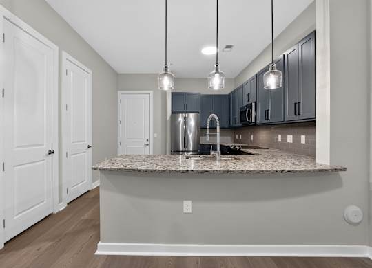 A kitchen with a granite countertop and a sink.