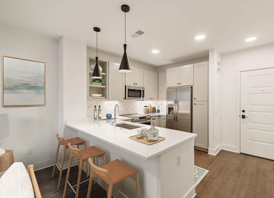 A kitchen with white cabinets and a white island with a wooden table and chairs. at The Sully, Chantilly, VA, 20151