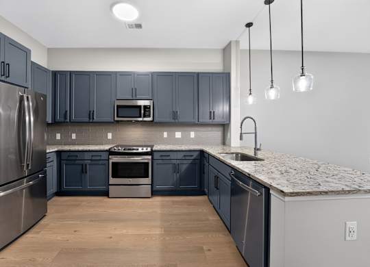 A kitchen with dark blue cabinets and stainless steel appliances.