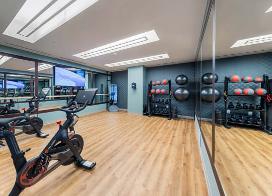 a gym with exercise machines and weights on a wooden floor at Hawkins Press, Charlotte, North Carolina