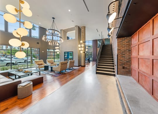 a lobby with couches and chairs and a staircase at Hawkins Press Apartments, Charlotte, NC