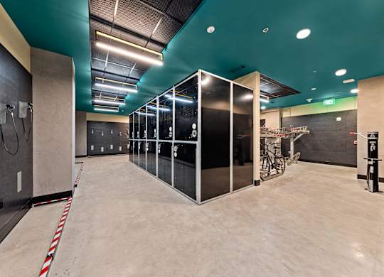 A gym with a row of mirrors on the wall at Hawkins Press Apartments, North Carolina, 28203