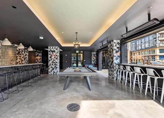 A modern dining area with a long table and chairs at Hawkins Press Apartments, Charlotte, NC, 28203