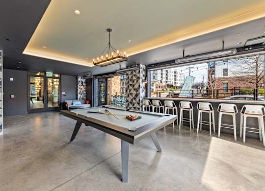 A modern dining area with a long table and chairs at Hawkins Press Apartments, Charlotte, 28203