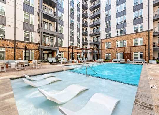 A swimming pool with a slide in the middle of it at Hawkins Press Apartments, North Carolina