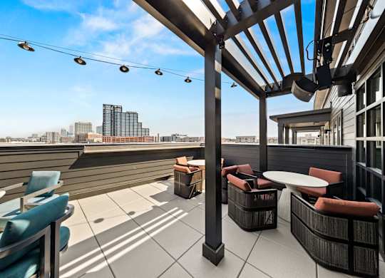 A rooftop patio with a view of the city skyline at Hawkins Press Apartments, North Carolina