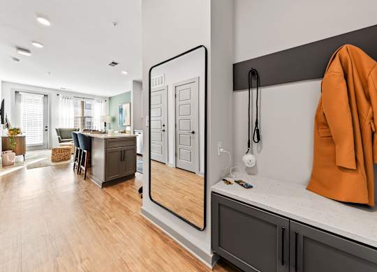 A modern kitchen with a wooden floor and a large mirror on the wall.