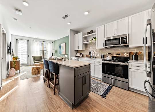 A modern kitchen with a large island and stainless steel appliances.