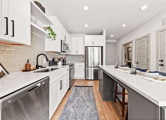 A modern kitchen with white cabinets and a stainless steel dishwasher.