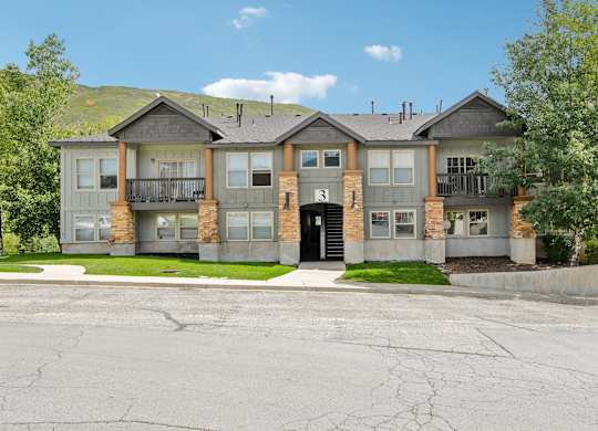 A large, two-story apartment building with a balcony on the second floor.