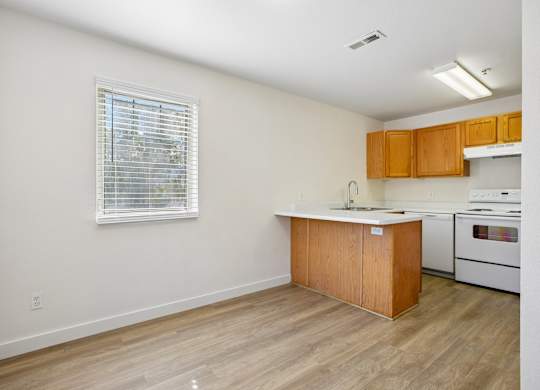 A kitchen with wooden cabinets and a white stove top oven.