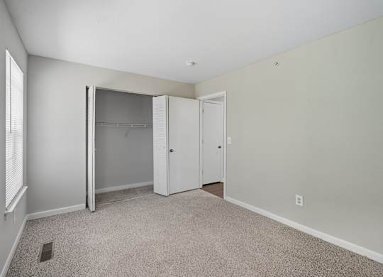 A room with a carpeted floor and a white closet with a sliding door. at Greens at Stonecreek, Georgia, 30038