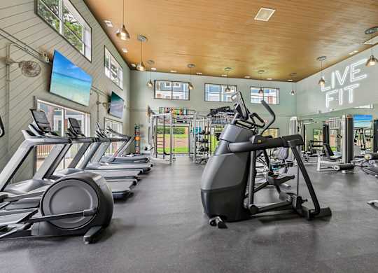 A gym with treadmills, elliptical machines, and other exercise equipment.