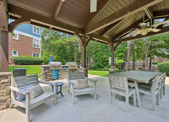 A patio with a table and chairs under a roof.