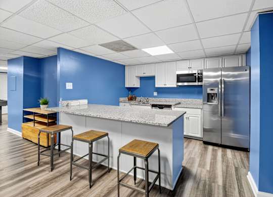 A kitchen with blue walls and a stainless steel refrigerator at Avondale Overlook, Hyattsville, 20782