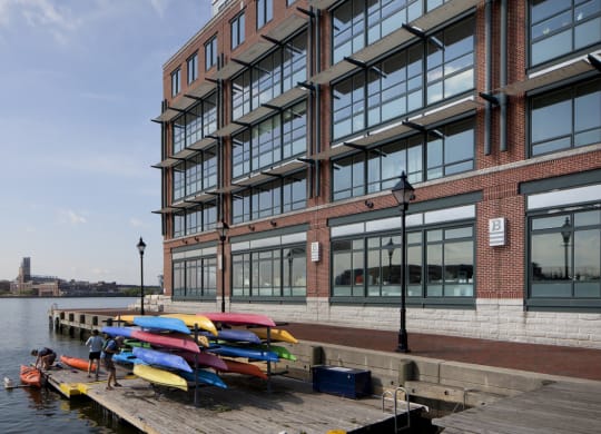 a row of colorful kayaks on a dock in front of a building at 1305 Dock Street, Maryland