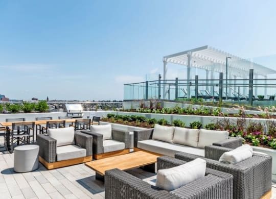 a roof top patio with chairs and tables at 1405 Point Street Apartments in Baltimore, MD