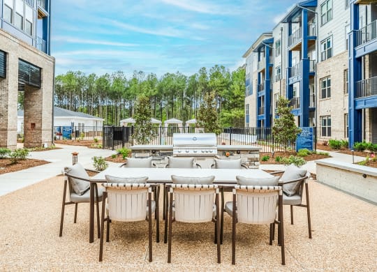 an outdoor patio area with a table and chairs and a grill at Preston Ridge, Cary, 27513