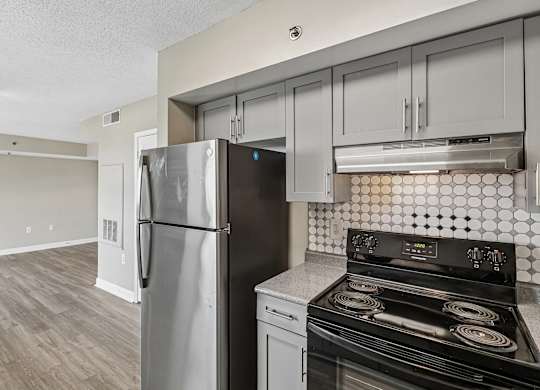 A kitchen with a black stove top oven and a black refrigerator.