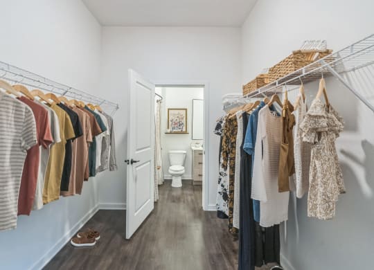 a closet with racks of clothes and a bathroom with a toilet  at La Unión, Florida, 33605