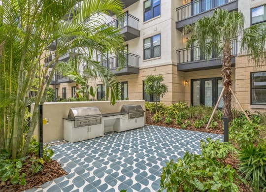 an outdoor patio with two grills in front of an apartment building  at La Unión, Tampa, 33605