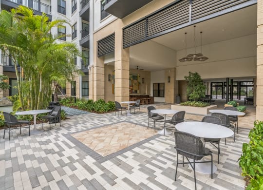 a courtyard with tables and chairs and a building in the background  at La Unión, Tampa, 33605