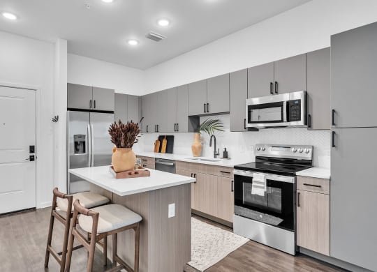 an open kitchen with stainless steel appliances and a counter with two chairs  at La Unión, Tampa, FL