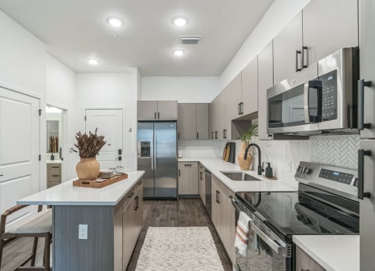 an open kitchen with stainless steel appliances and white cabinets  at La Unión, Tampa, FL