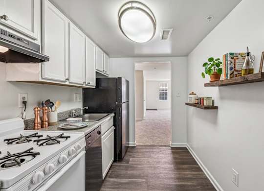 A kitchen with white cabinets and a black refrigerator.