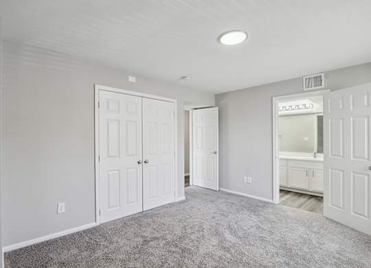 A room with a carpeted floor and a white door at Shenandoah Station Apartments, Virginia