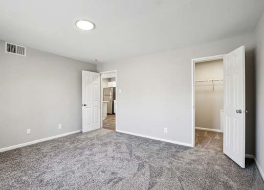 A room with carpeted floor and two open doors at Shenandoah Station Apartments, Triangle, 22172