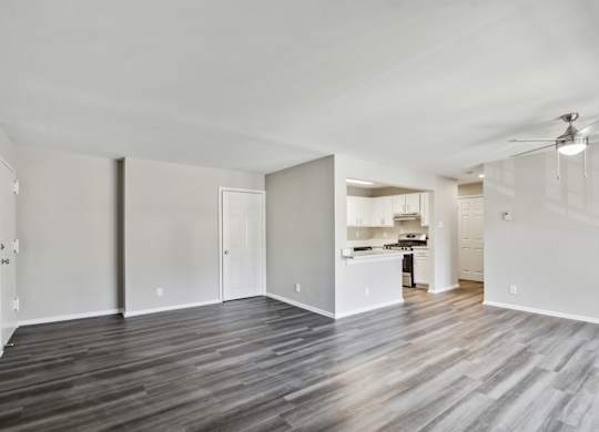A spacious room with wooden flooring and white walls at Shenandoah Station Apartments, Triangle, Virginia
