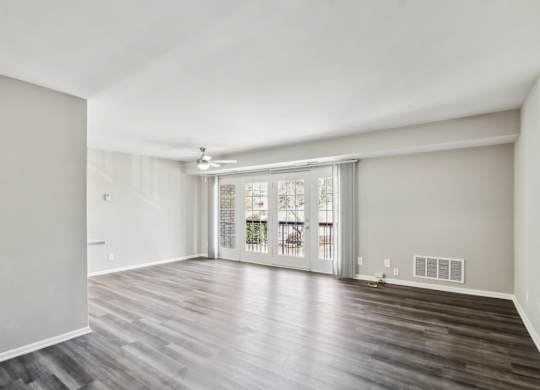 A room with wooden flooring and a sliding glass door at Shenandoah Station Apartments, Virginia 22172
