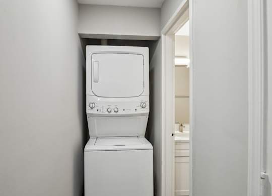 A white washing machine in a small room at Shenandoah Station Apartments, Triangle, VA