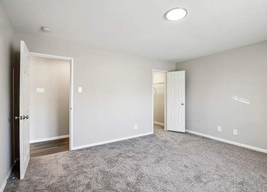 A room with a carpeted floor and two open doors at Shenandoah Station Apartments, Virginia 22172