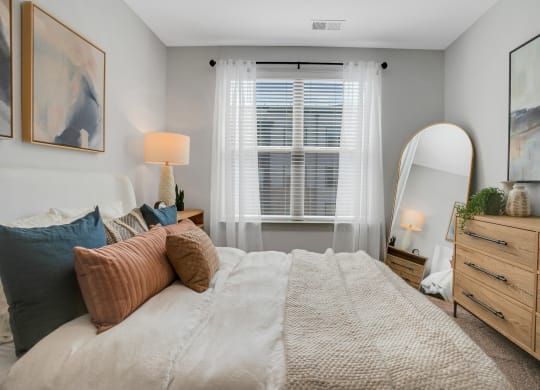 a bedroom with a large bed and a mirror at Preston Ridge, Cary