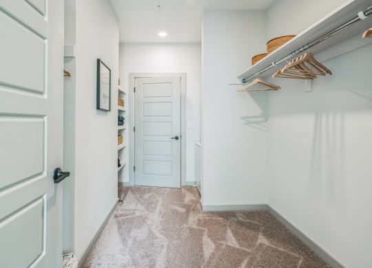 a hallway with a closet and a white door at Preston Ridge, Cary, 27513