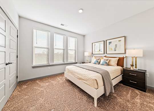 A bedroom with a bed, dresser, and two framed pictures on the wall.