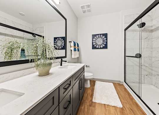 A bathroom with a white counter top and a wooden floor.