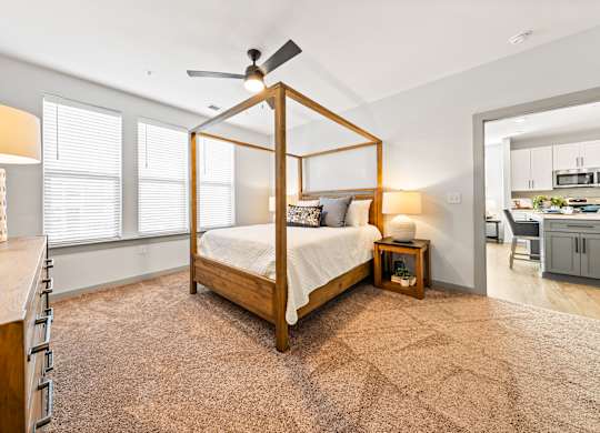 A bedroom with a four poster bed and a ceiling fan.