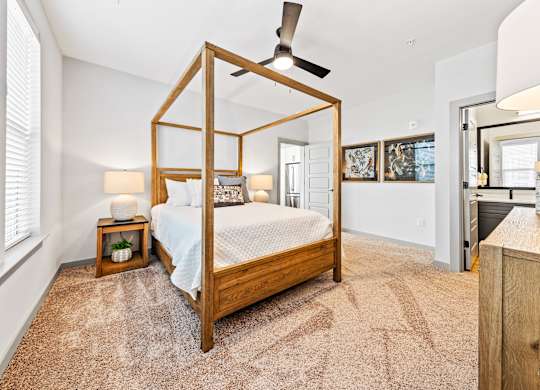 A bedroom with a four poster bed and a carpet.