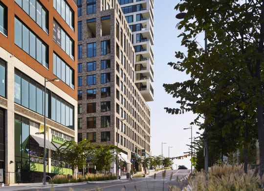 a cityscape with tall buildings and a street in the foreground at The Boro, Tysons Virginia