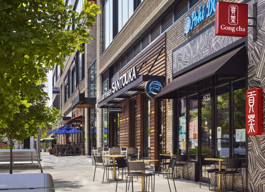 a sidewalk with tables and chairs in front of a restaurant at The Boro, Tysons, VA 22102