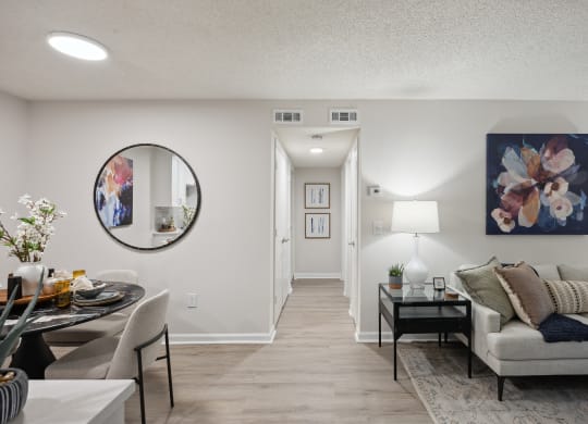 the living room and dining room of an apartment with a couch and a table at St. Andrews Reserve, Wilmington, NC
