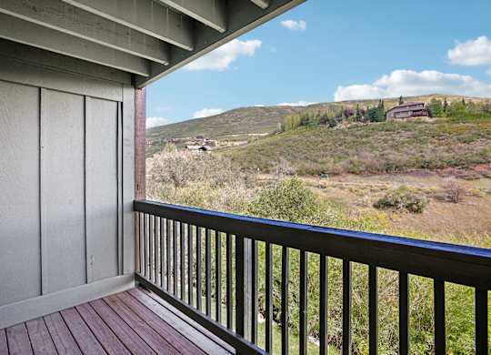 A balcony with a view of a hilly landscape.