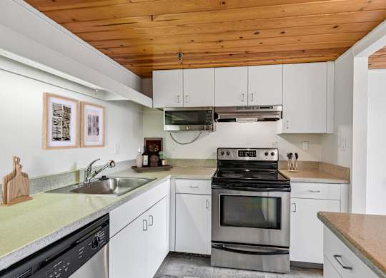 A modern kitchen with a stove top oven and a microwave above the stove.